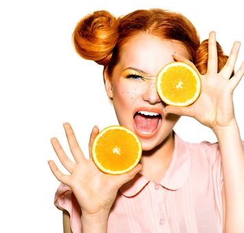 Joyful teen girl with funny red hairstyle. Juicy oranges